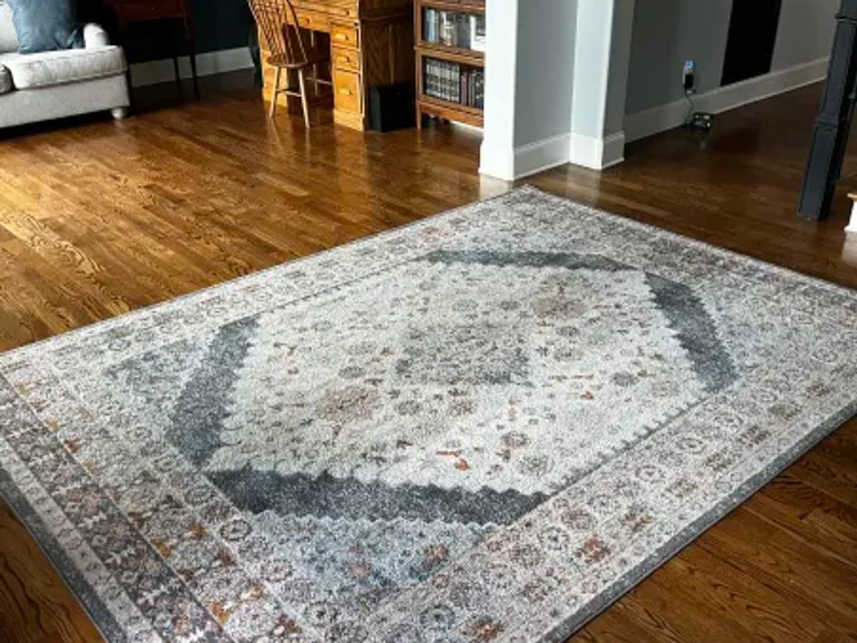 Gray and rust medallion rug lying flat in a home den after cleaning and enzyme treatment