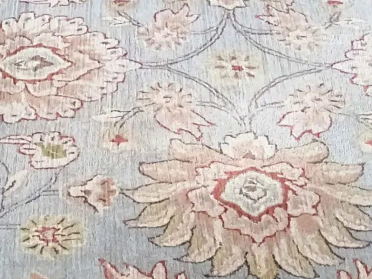 Pale blue wool rug with salmon colored florals after cleaning, the nap standing open again
